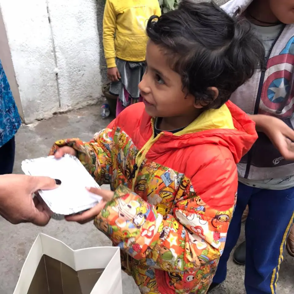 A child happily receives a food packet