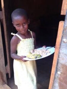 Kenyan girl happily poses with her meal