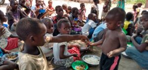 Malawi children sitting together and sharing food