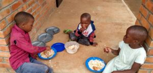 Three children having a meal at Not Another Child center