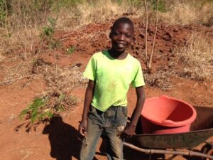 A Malawi boy grins widely while being clicked