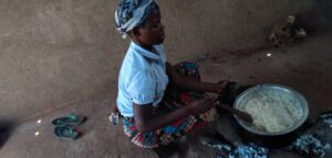 Malawi mother preparing food at Not Another Child center