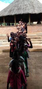 Children happily waving hands in queue