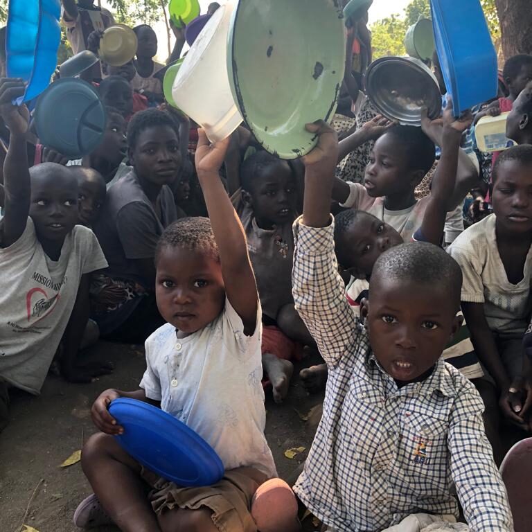 Kids sitting down and showing their empty plates